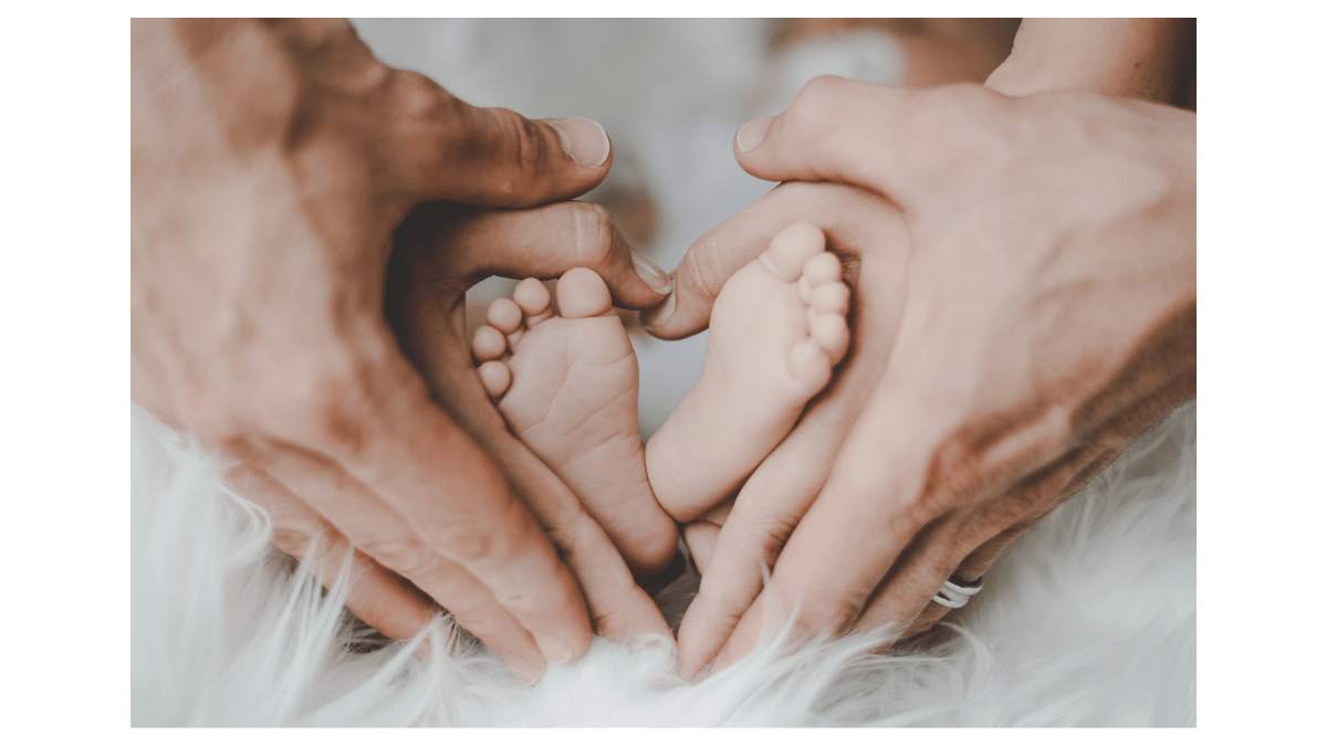 Baby feet cradled in parents' hands forming a heart